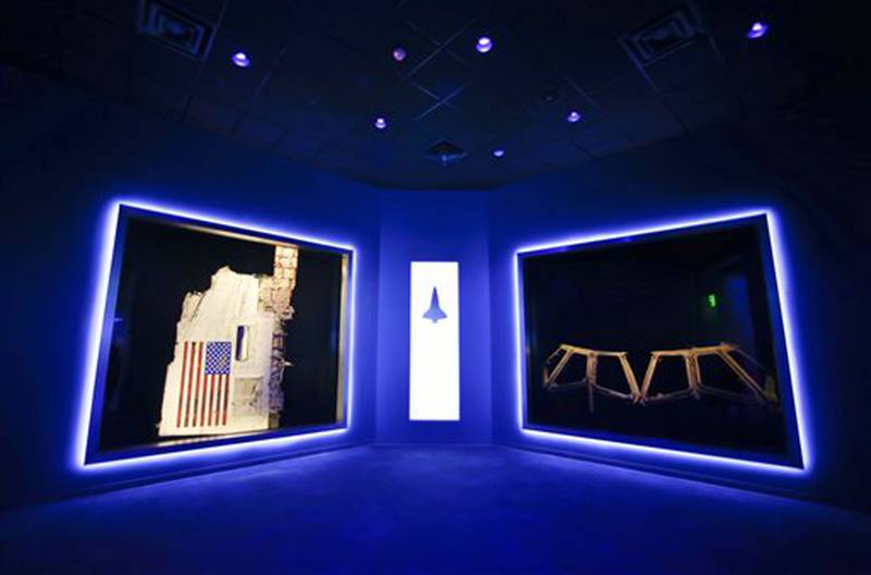 This Tuesday, July 21, 2015 photo shows a side body panel of space shuttle Challenger, left, and the cockpit windows of Columbia, right, displayed at the Forever Remembered exhibit and memorial for the astronauts that perished on the two shuttles at the Kennedy Space Center Visitor Complex, in Cape Canaveral, Fla. (AP Photo/John Raoux)
