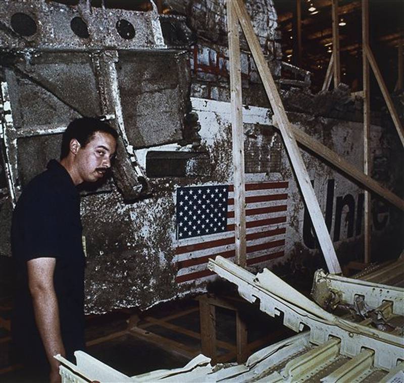 John White, National Transportation Safety Board inspector, stands near the left side of the wreckage of the Space Shuttle Challenger, Wednesday, April 10, 1986, Kennedy Space Center, Fla. The press was allowed to view the Challenger wreckage for the first time. (AP Photo)