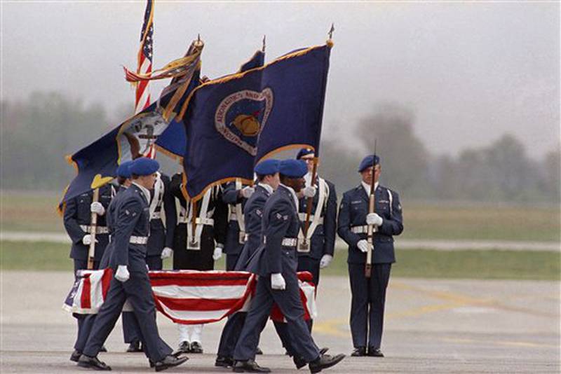 The remains of one of the crew of the Space Shuttle Challenger are carried past an honor guard on the tarmac at Dover Air Force Base in Dover, Delaware on Tuesday, April 29, 1986. The remains of the seven astronauts killed in the January Shuttle explosion were brought to the base to be prepared for burial. (AP Photo/Amy Sancetta)