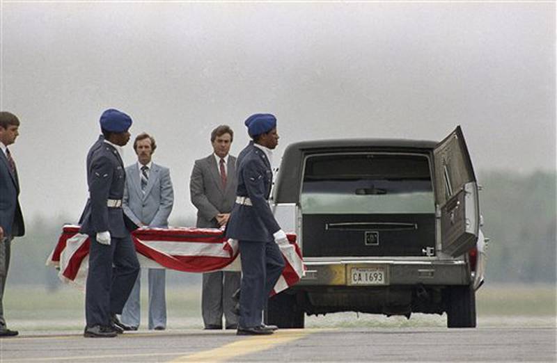 The remains of one crewmembers of the Space Shuttle Challenger are carried to a hearse on the tarmac at Dover Air Force Base in Dover, Delaware on Tuesday, April 30, 1986. The remains of all seven astronauts killed in the Shuttle explosion on January 28, were taken to Dover AFB for burial preparation. (AP Photo/Amy Sancetta)
