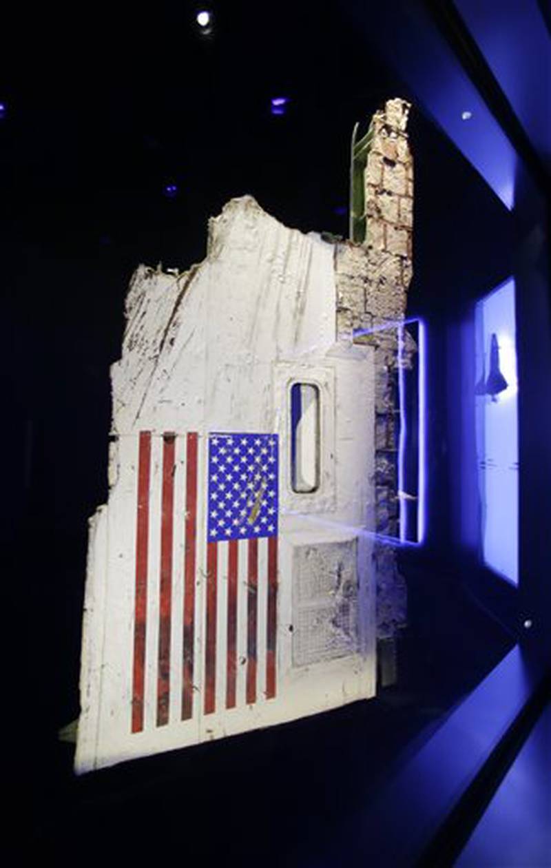 In this Tuesday, July 21, 2015, photo, the left side body panel of space shuttle Challenger is displayed in a glass case at  the "Forever Remembered" exhibit at the Kennedy Space Center Visitor Complex in Cape Canaveral, Fla. Challenger's wreckage _ all 118 tons of it, salvaged from the Atlantic _ was buried in a pair of former missile silos, 90 feet deep. The chamber containing this particular fuselage section had never been opened _ until the exhibit began to take shape. (AP Photo/John Raoux)